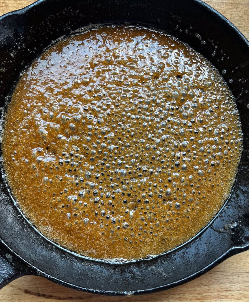 Melted butter and brown sugar in a cast iron frying pan.