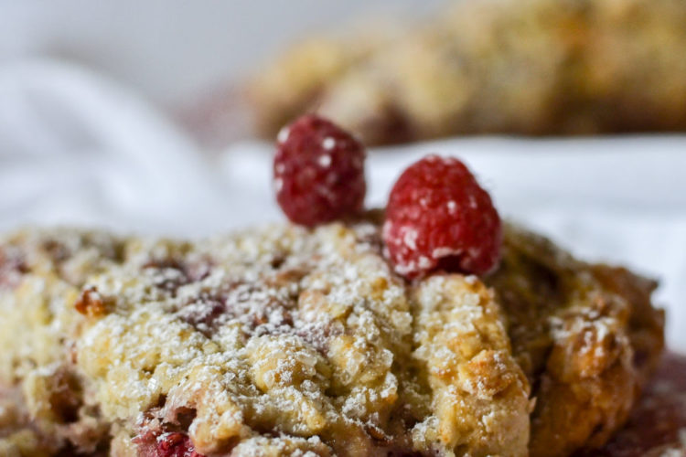 Raspberry Scone dusted with icing sugar on a red transferware plate