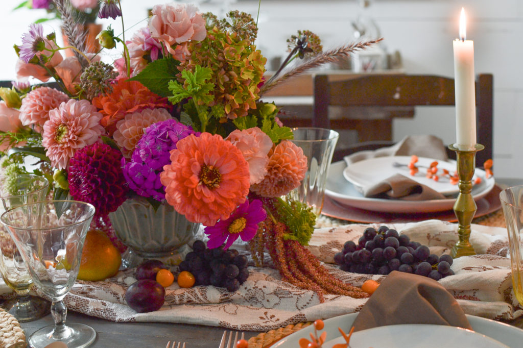 Autumn tablescape with a brightly coloured centrepiece in pink and orange.
