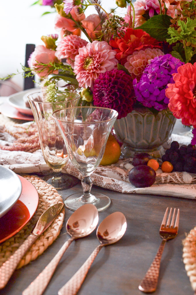 Fall tablescape with Cooper flatware and a pink orange and purple dahlia centrepiece.