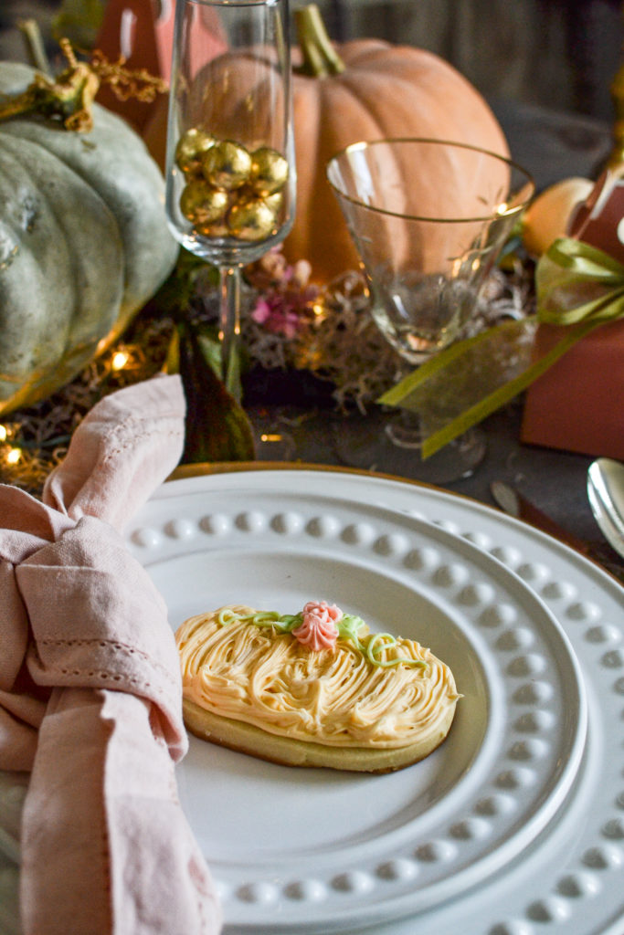 Pumpkin sugar cookie decorated with pastel orange, pink and green