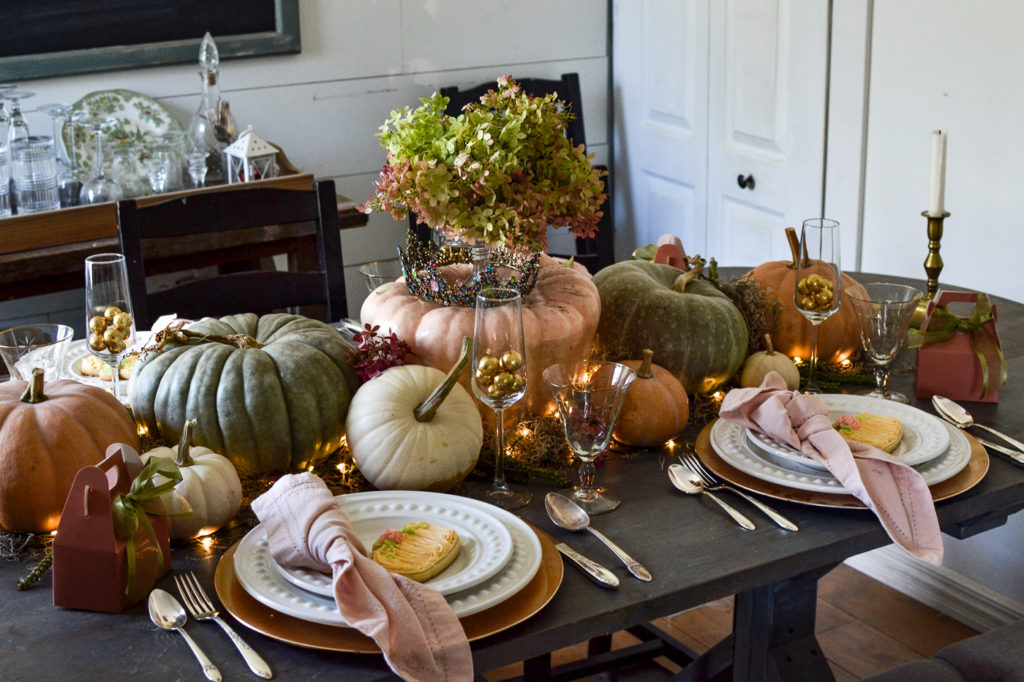 Pumpkin themed Halloween tablescape with fresh pumpkins of all shapes, sizes and colours