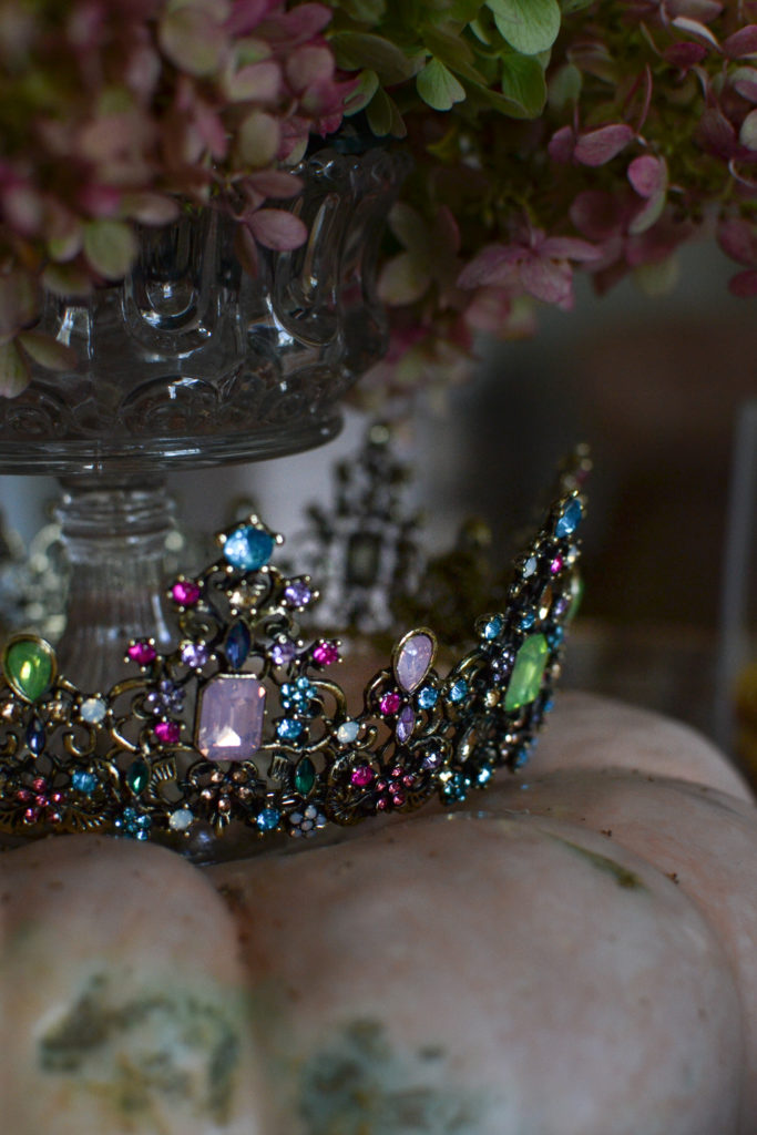 Sparkly jewelled crown on top of an orange pumpkin