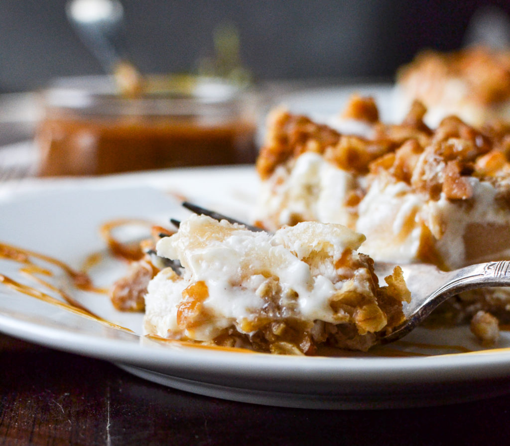 A side view of a slice of frozen apple crisp  dessert that has been cut into with a fork.