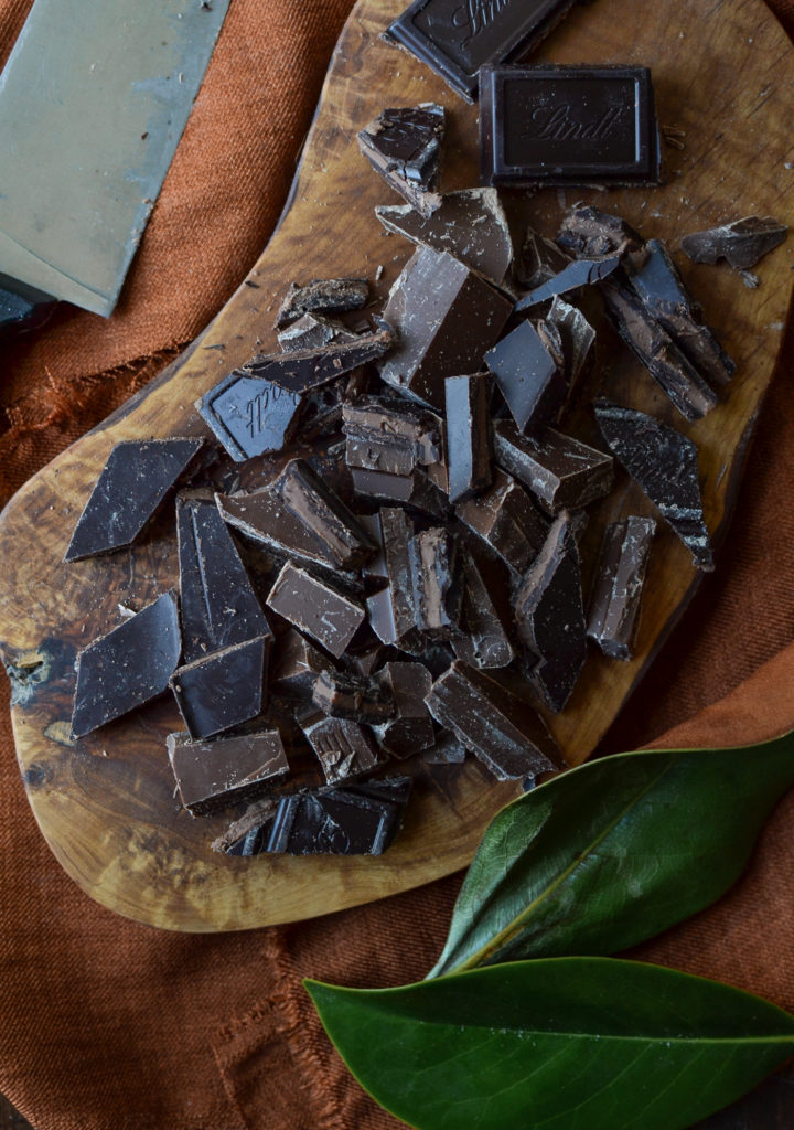 A cutting board piled with chopped milk and dark chocolate
