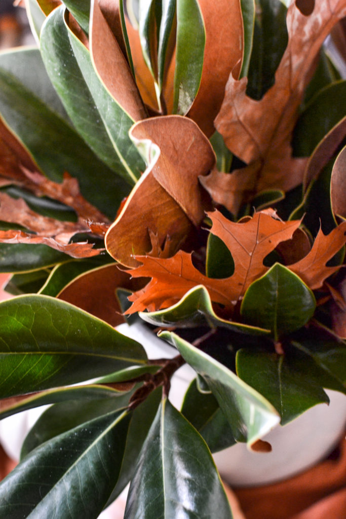 oak leaves tucked into a magnolia centerpiece viewed from above.