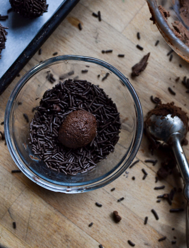 a bowl of chocolate sprinkles with a rum ball in the middle.
