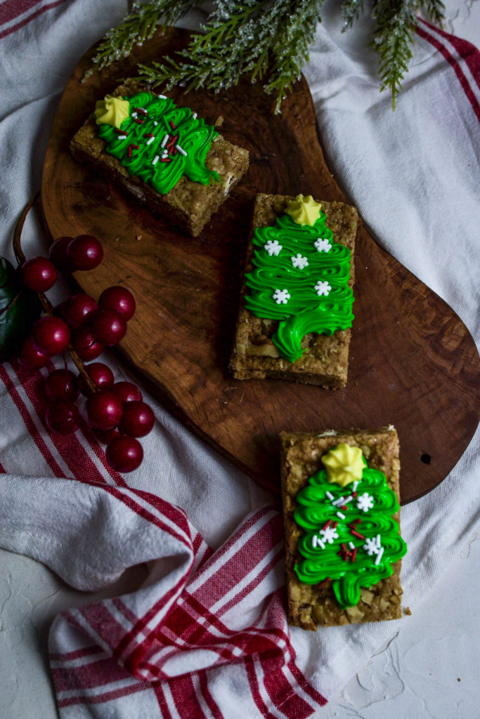 An overhead view of christmas bar cookies decorated with green Christmas trees.