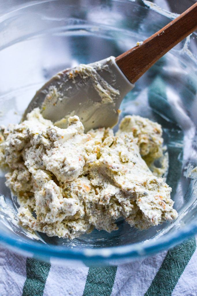 A mixing bowl with a mixture of creamy cheeses and spices