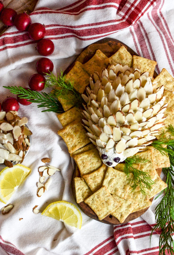 Overhead view of a hedgehog cheese ball surrounded by wheat thin crackers