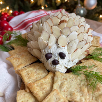 A cheeseball doted with almonds and surrounded by crackers