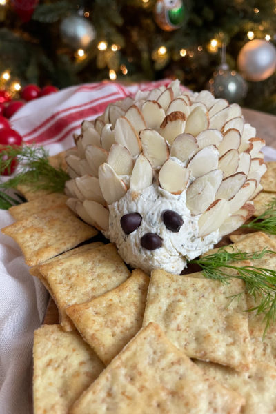 A cheeseball doted with almonds and surrounded by crackers