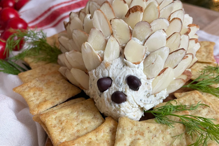 A cheeseball doted with almonds and surrounded by crackers