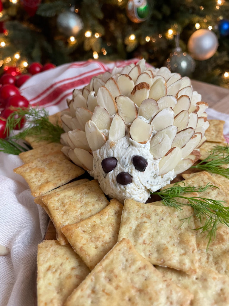 A cheeseball doted with almonds and surrounded by crackers