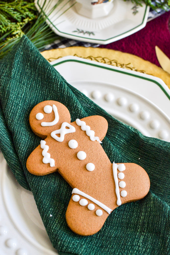 A gingerbread man cookie sits on top of a green napkin.