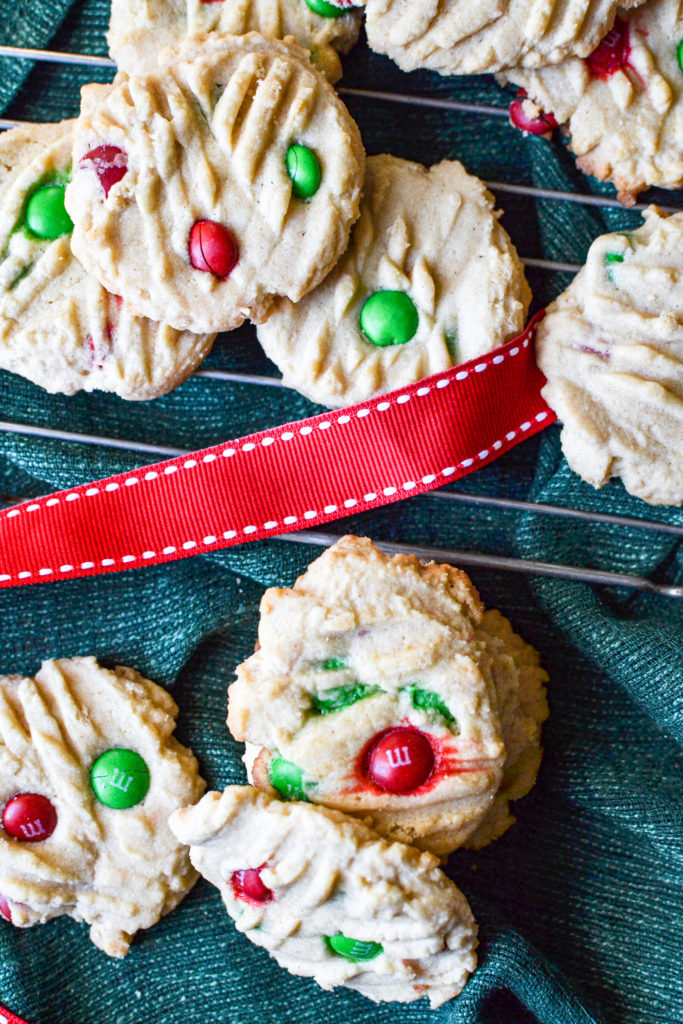 m&m peanut butter cookies piled on a cooling rack.