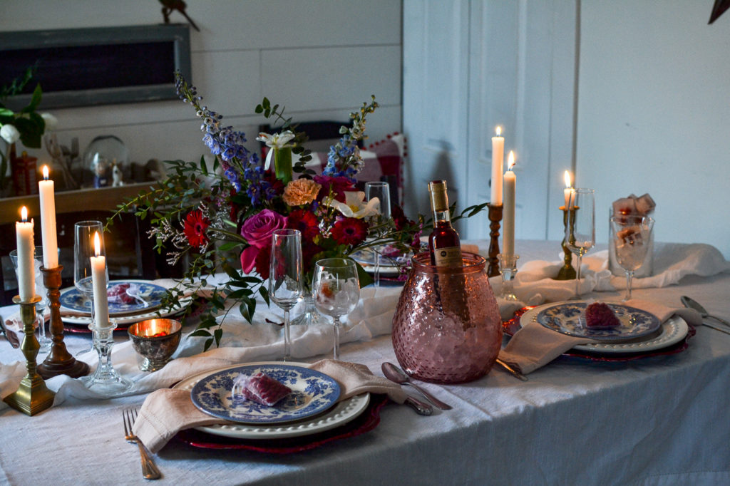 Valentine's Day Tablescapes with a colourful floral centerpiece, blue transfer ware plates and lots of lit candles