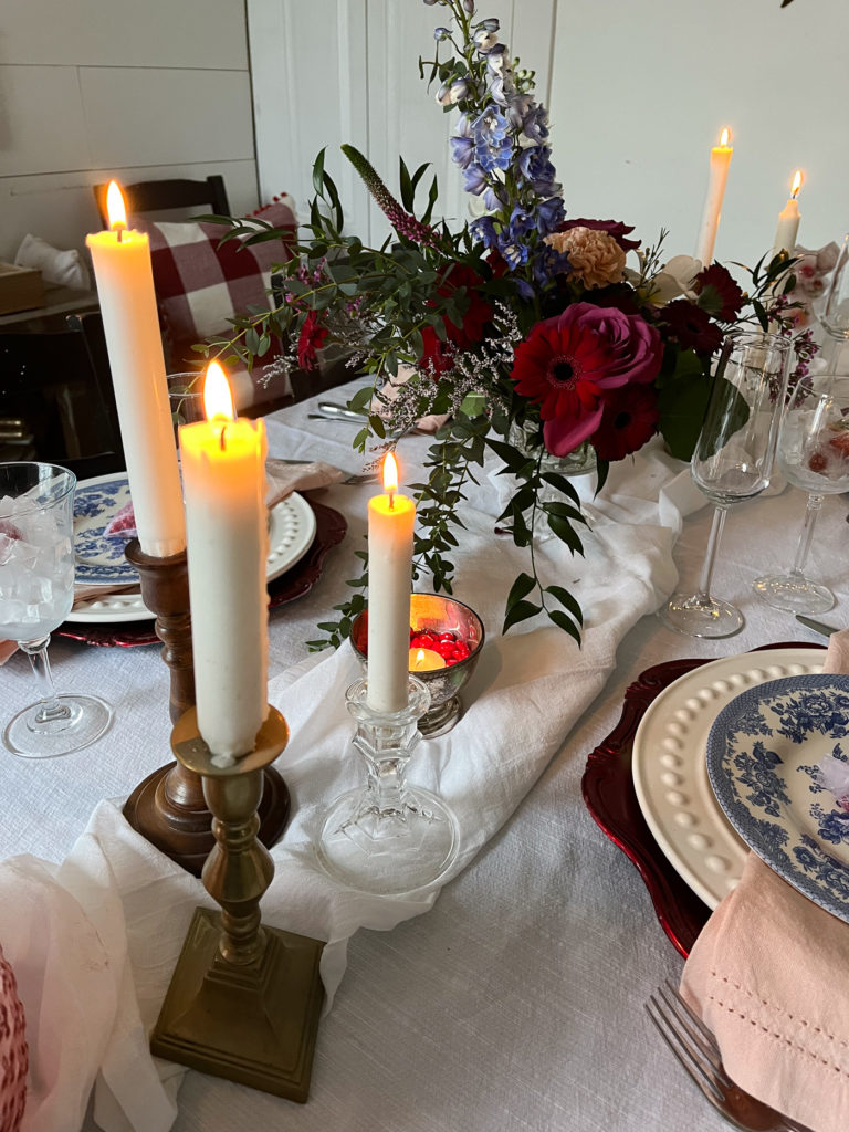 Lit candles on a valentines tablescape.