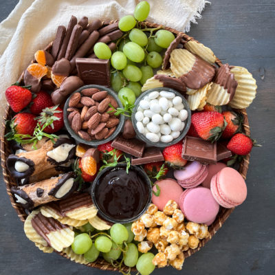 The ultimate dessert grazing board loaded with cookies, cannolis, caramel corn, chocolate dipped potato chips and fresh fruit.