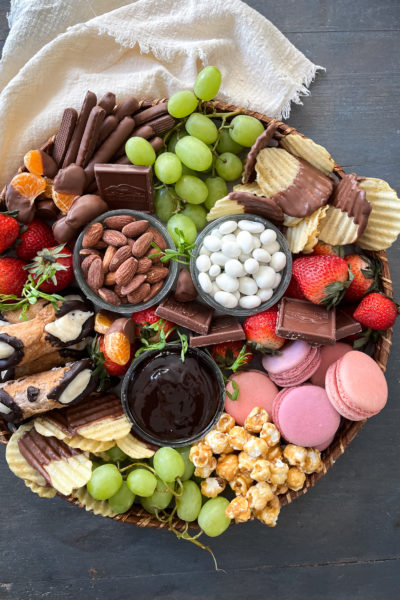 The ultimate dessert grazing board loaded with cookies, cannolis, caramel corn, chocolate dipped potato chips and fresh fruit.