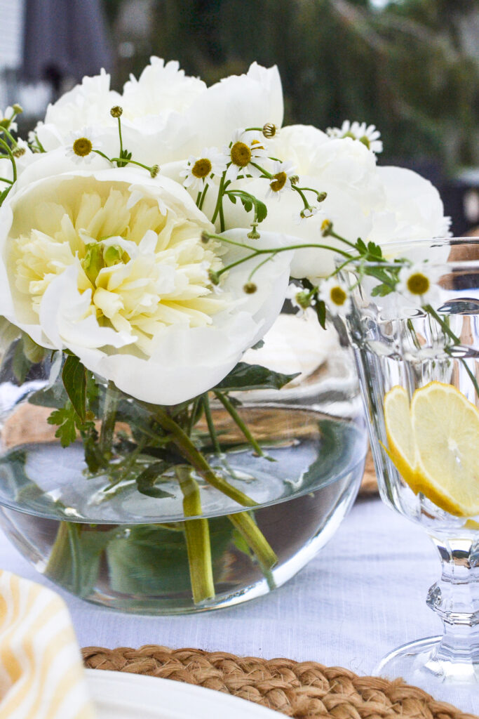 A rose bowl filled with white peonies and chamomile flowers