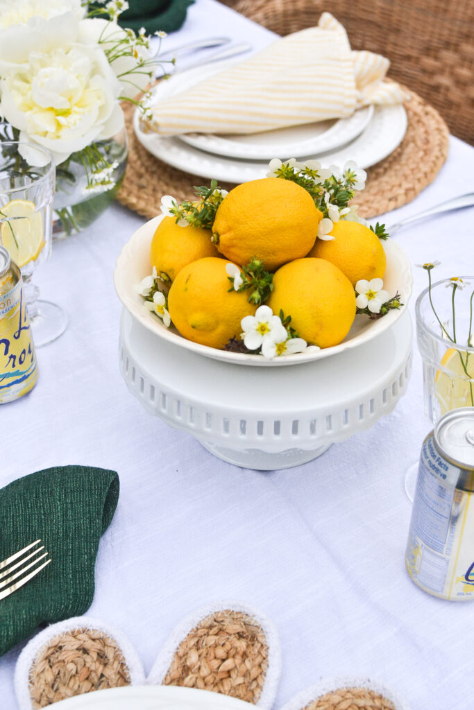 A table set in a lemon theme with a centrepiece made of lemons and camomile blossoms