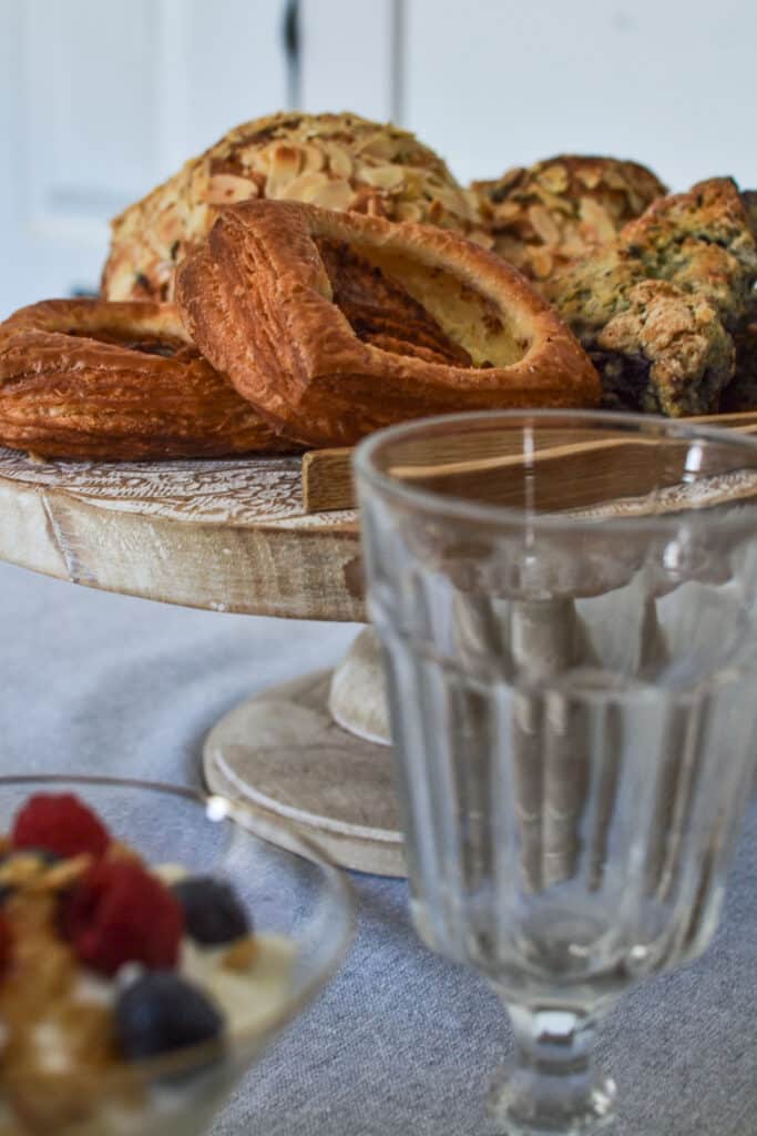 A plate of fresh pastries including almond crescents and apple danish for a bunch table setting.