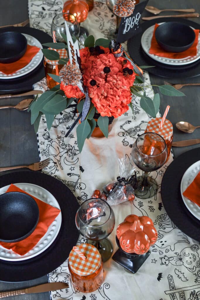 An overhead view of a halloween tablescape decorated in orange and black.