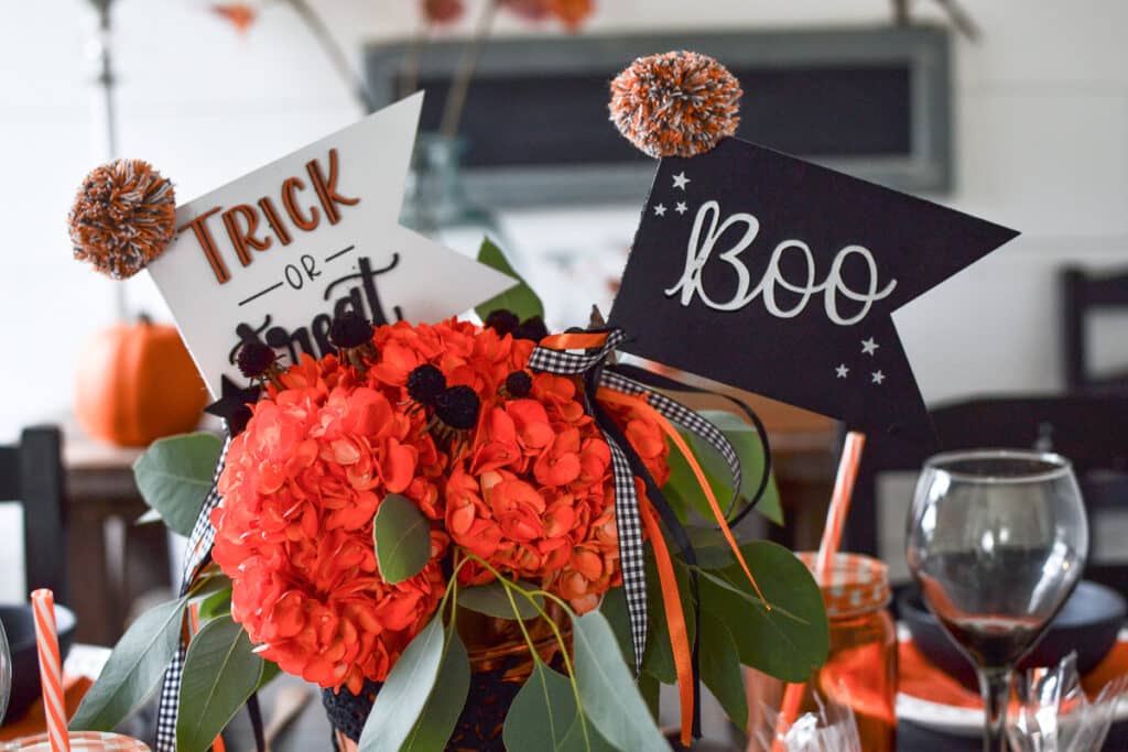 Orange hydrangeas with a banner that says trick or treat and a banner that says boo.