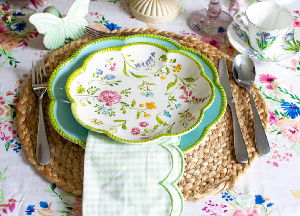 A brightly coloured floral plate on a table decorated in a spring fling theme.
