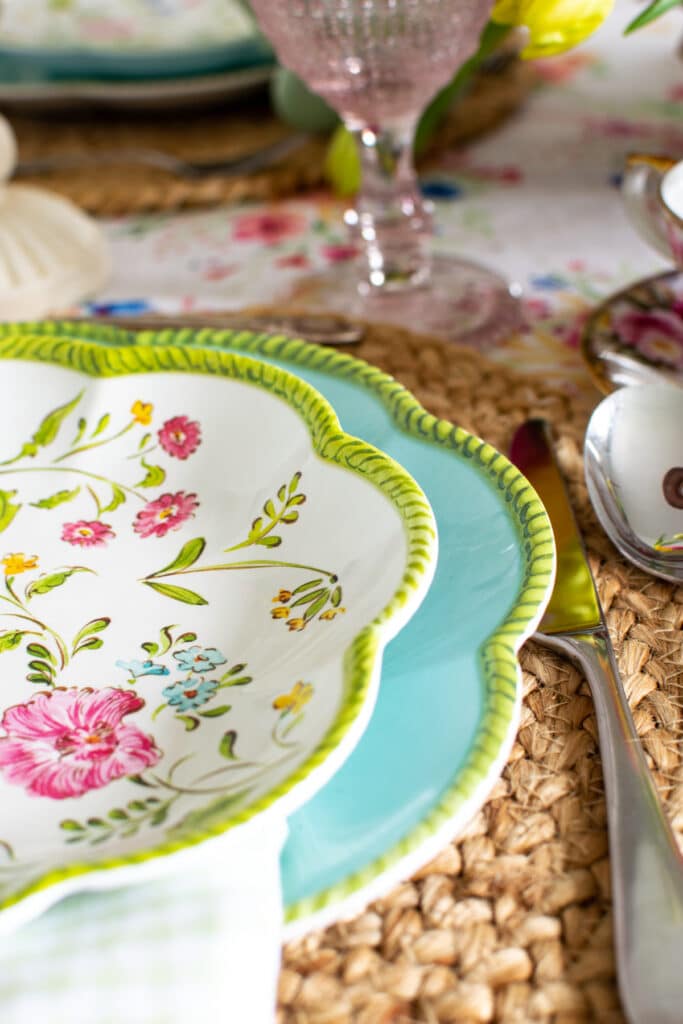 Robins egg blue dinner plate with a green edge is topped with a floral salad plate with a green edge.