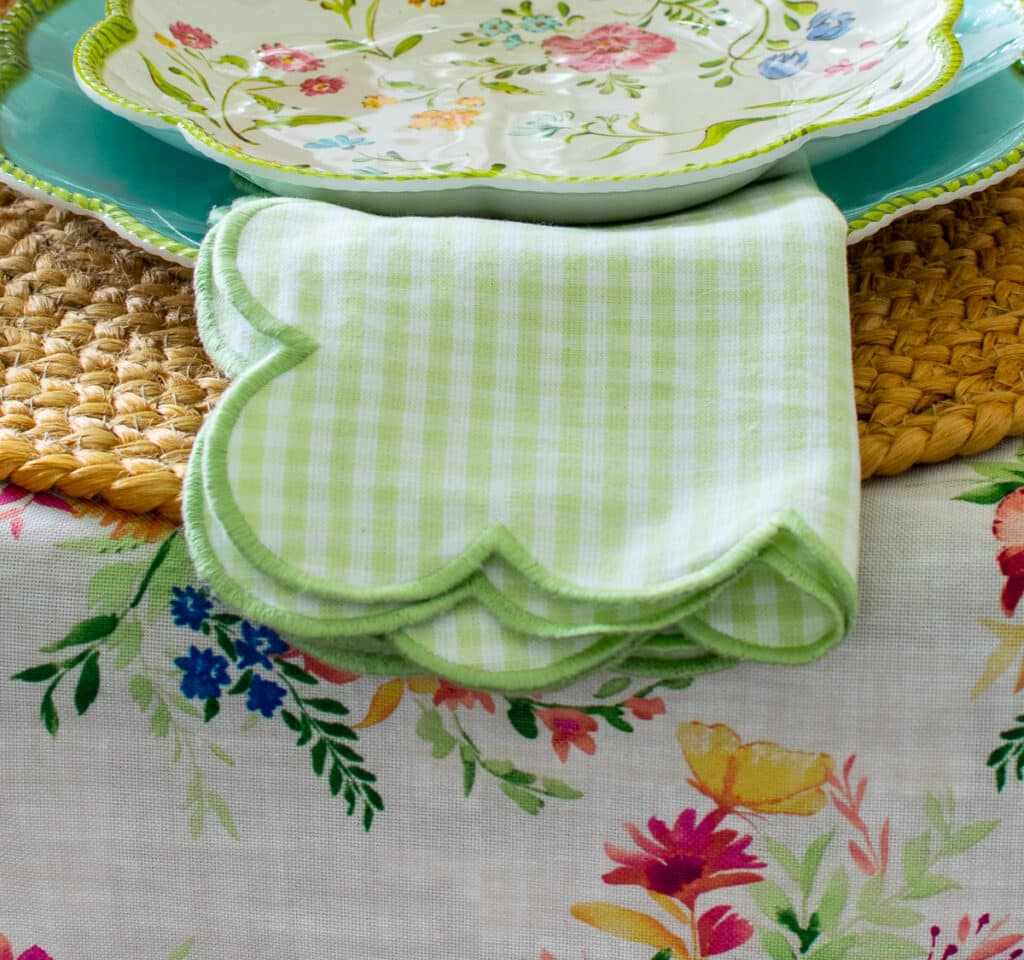 Green and white gingham napkin with a scalloped edge.