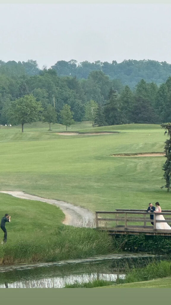 Bride and groom photographed on a bridge on a golf course