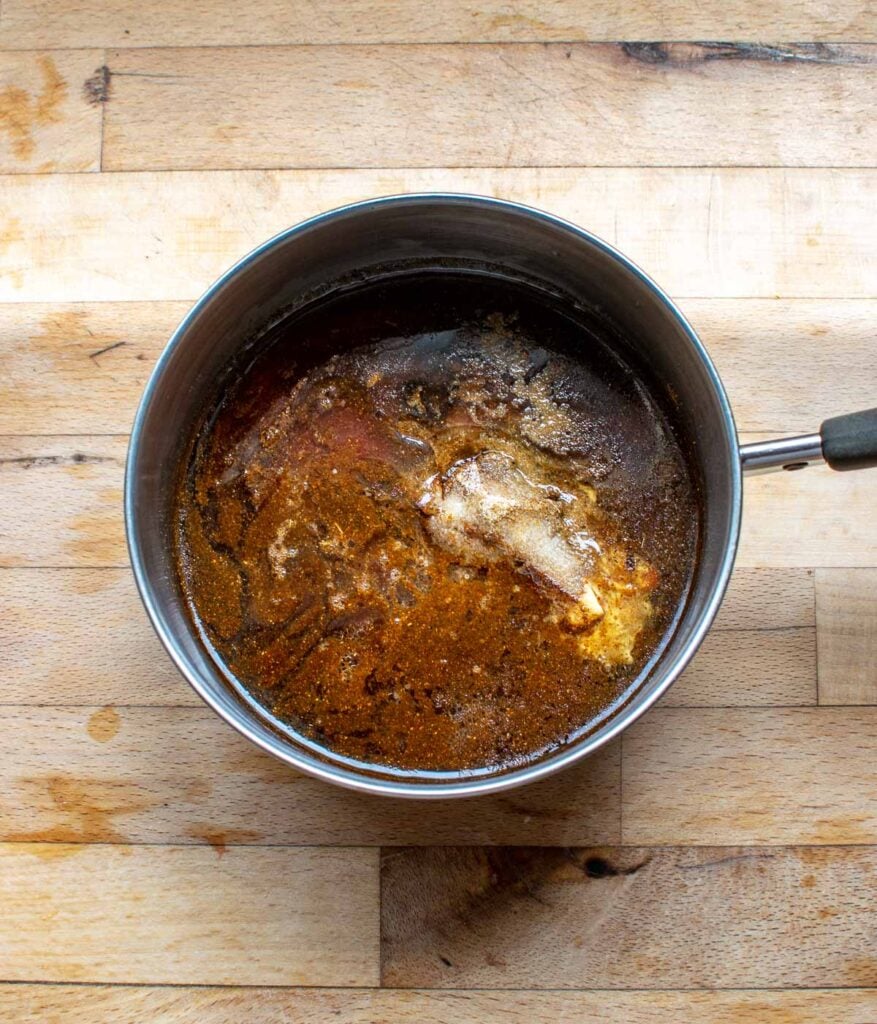 Spices, oil, vinegar and brown sugar in a small saucepan before being cooked.