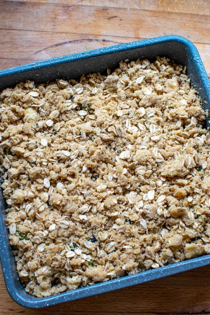Fruit filling completely covered with crumble topping ready for the oven.