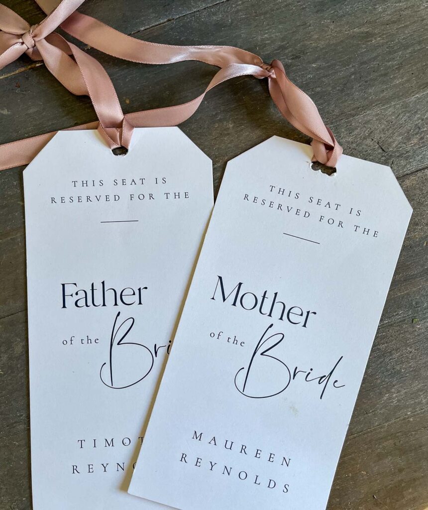 Tags that say This seat reserved for Mother of the Bride and Father of the Bride.