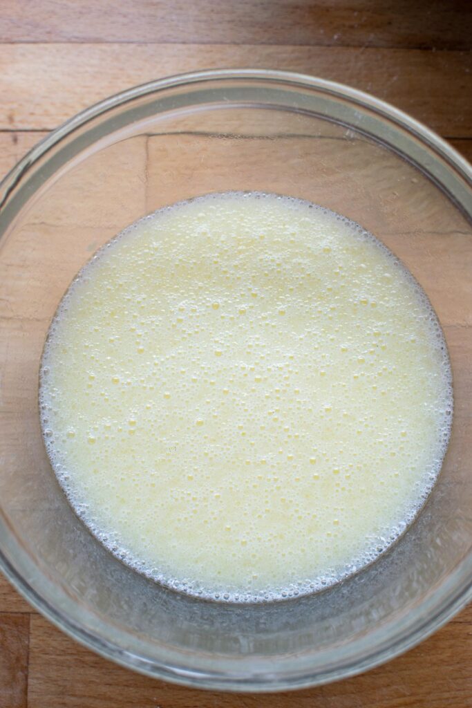 wet ingredients for muffins whisked together in a glass mixing bowl.