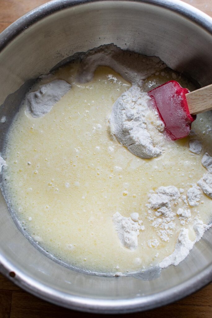 Wet muffin ingredients added to dry muffin ingredients in a mixing bowl.
