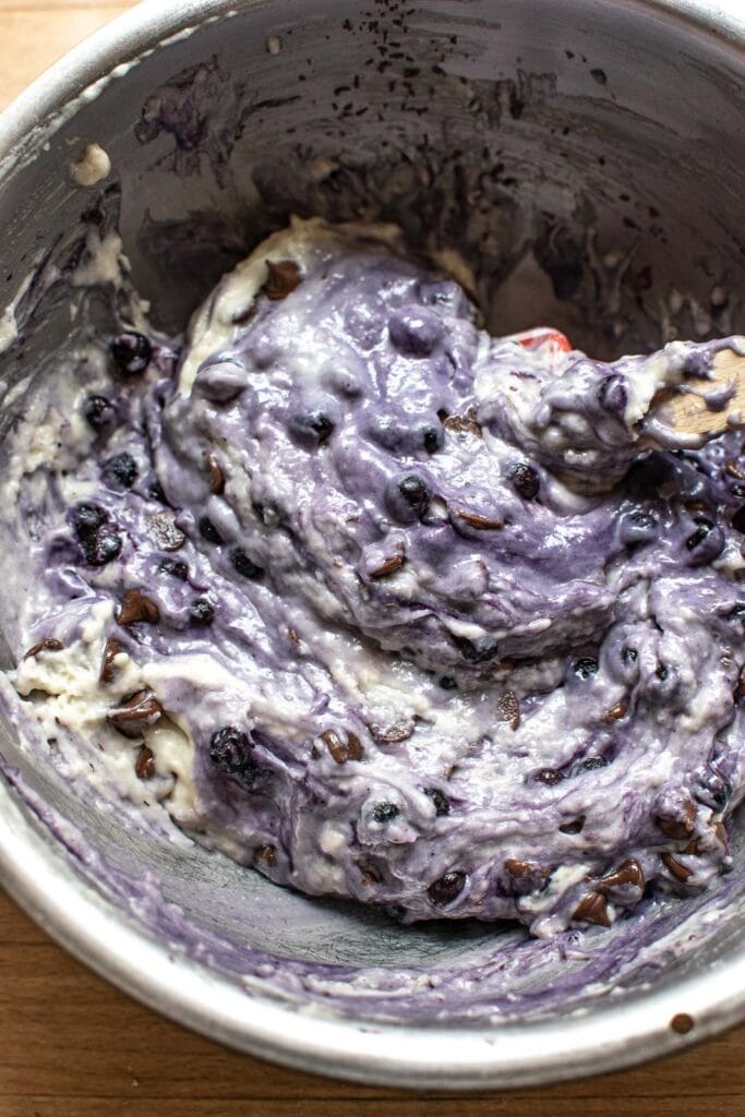 Chocolate chips and blueberries stirred into muffin better in a mixing bowl.