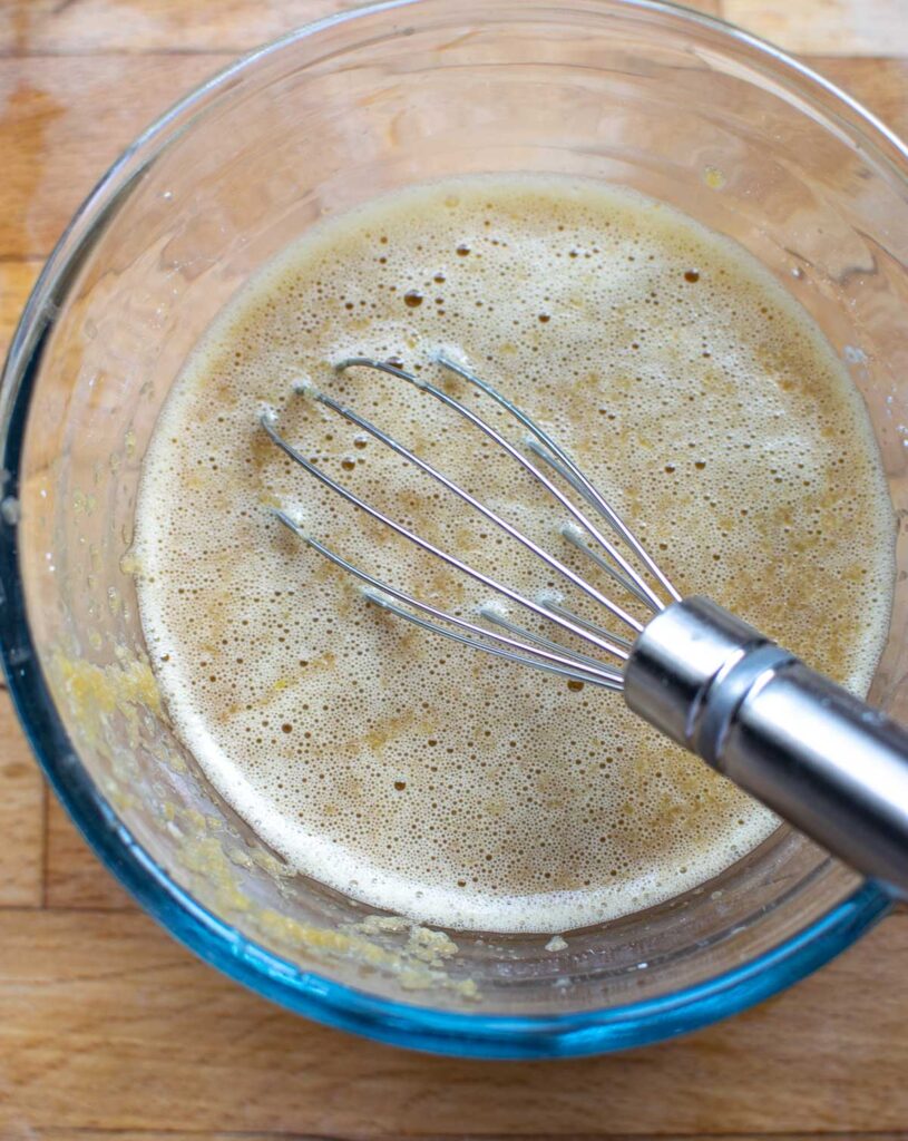 Soya sauce, cornstarch, vinegar, and peach puree whisked together in a glass bowl.