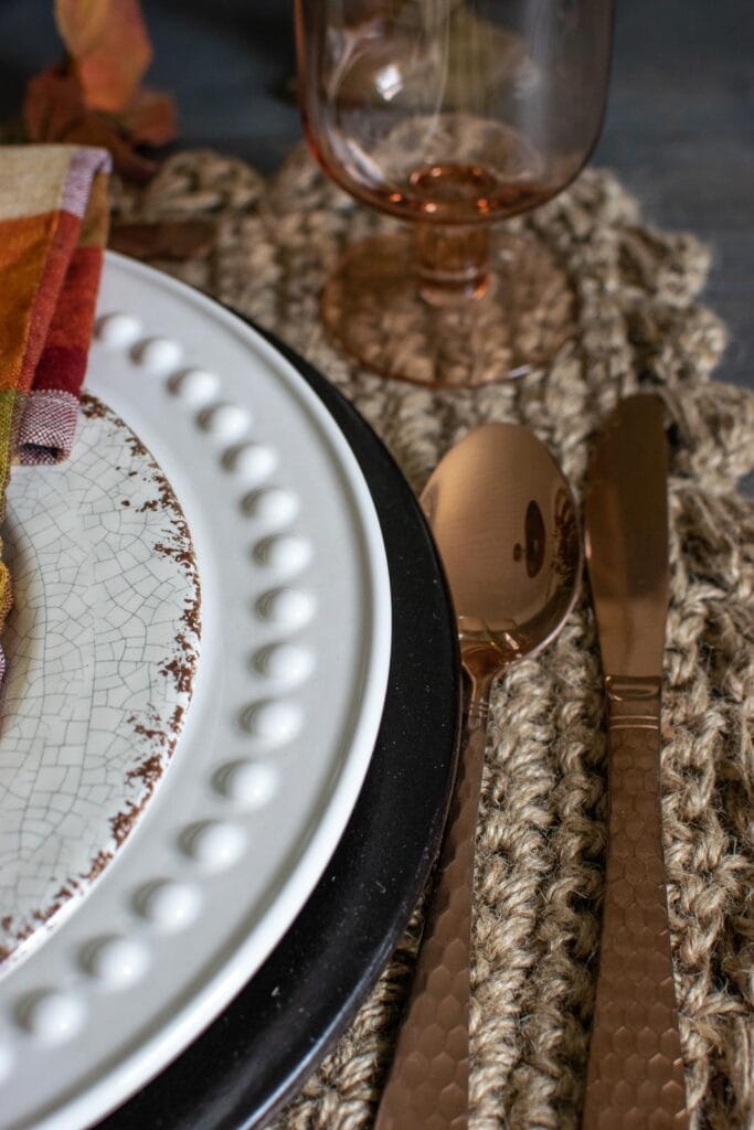 Copper flatware on a jute placemat.