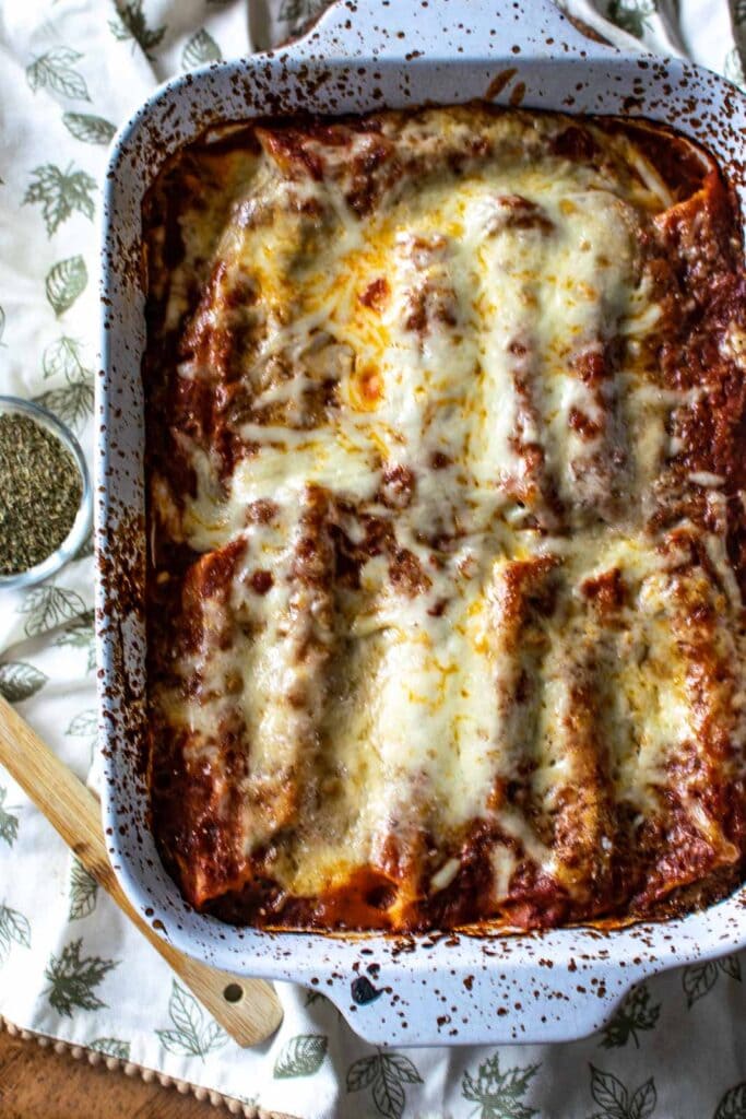 Fully cooked chicken spinach manicotti topped with melted cheese fresh from the oven.