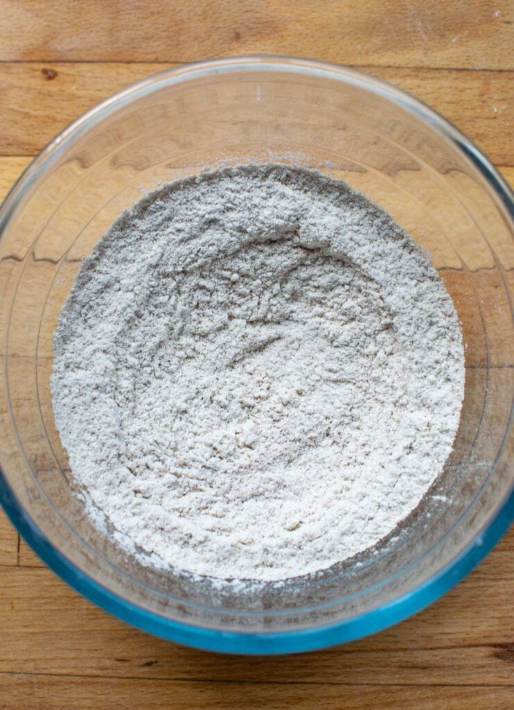 Flour and spices sifted together in a glass mixing bowl for a pumpkin sponge cake.