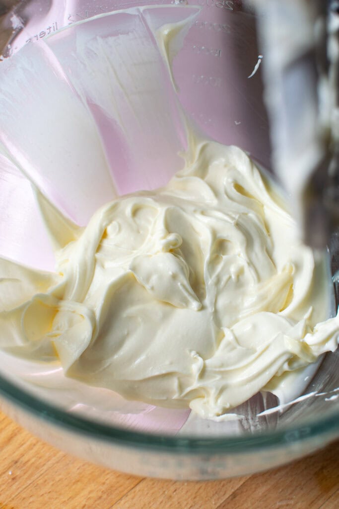 Whipped cream cheese filling in a glass mixing bowl.