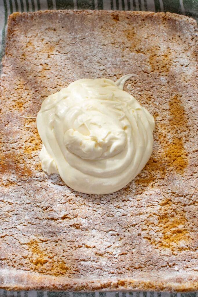 Cream cheese filling in the centre of a jelly roll cake before spreading.