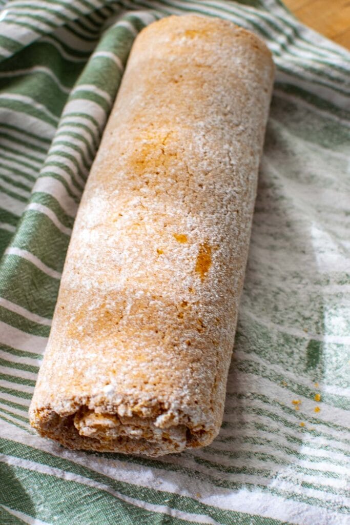 Pumpkin roll cake with cream cheese filling after being rolled up.