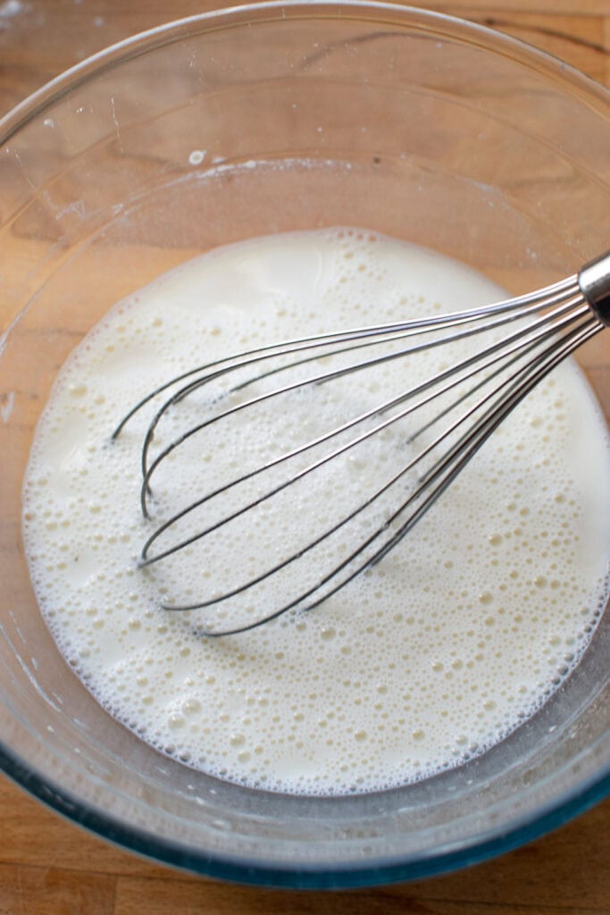 Milk and flour whisked together in a mixing bowl.