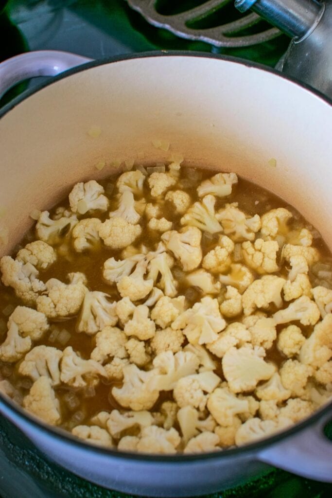 Chicken Broth and cauliflower florets added to the pot with the softened onions.
