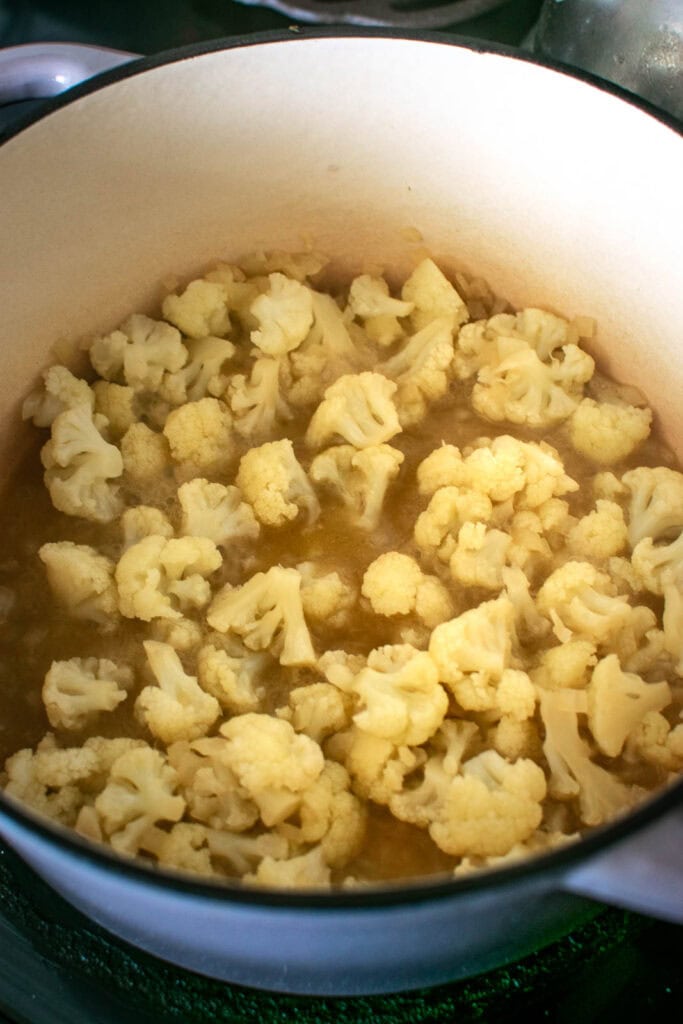 Cauliflower florets that have been boiled in a chicken broth to make soup.
