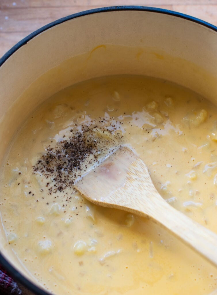 Salt and pepper added to cauliflower and cheddar cheese soup.